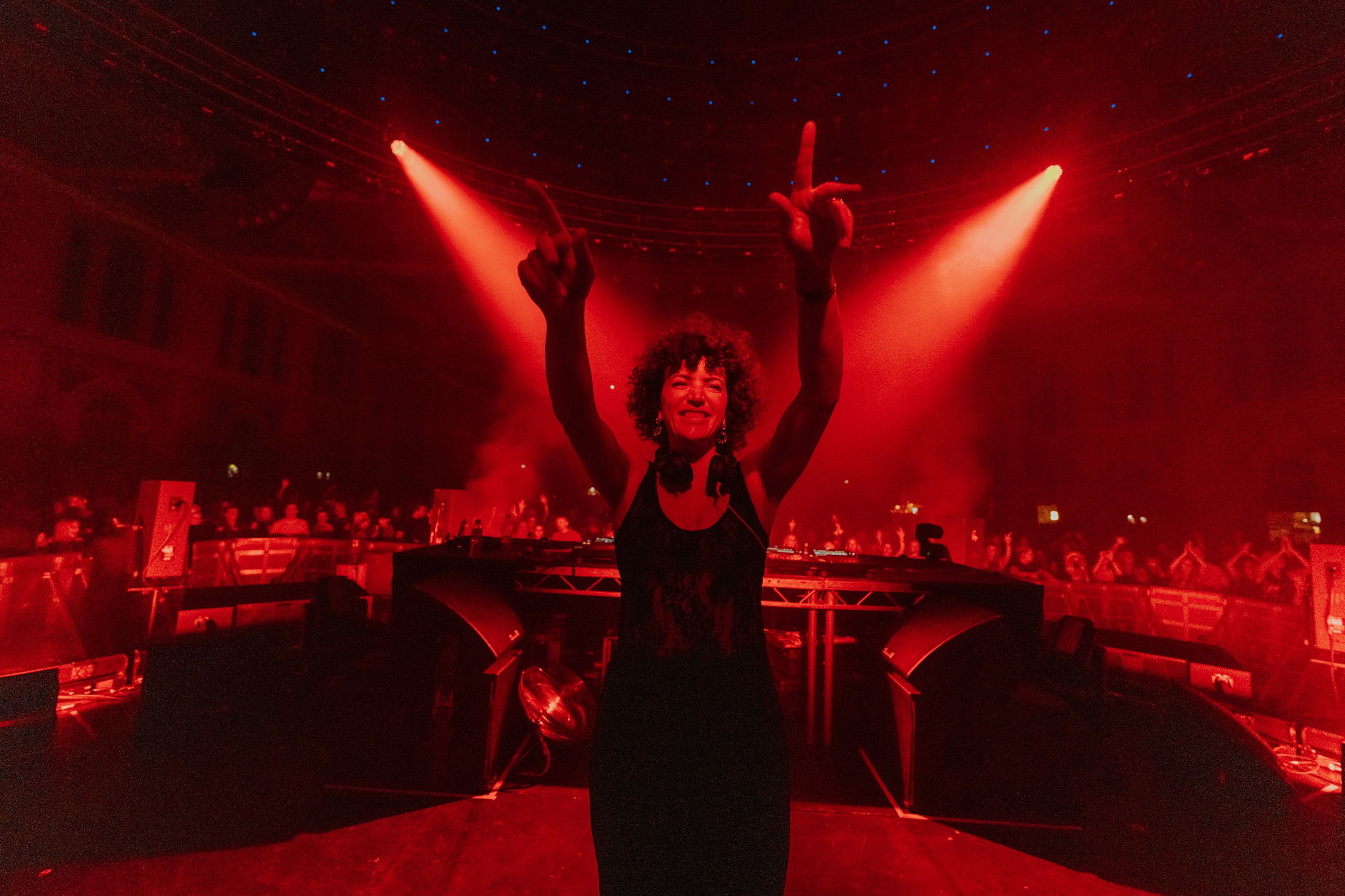 Annie with both arms raised in red light