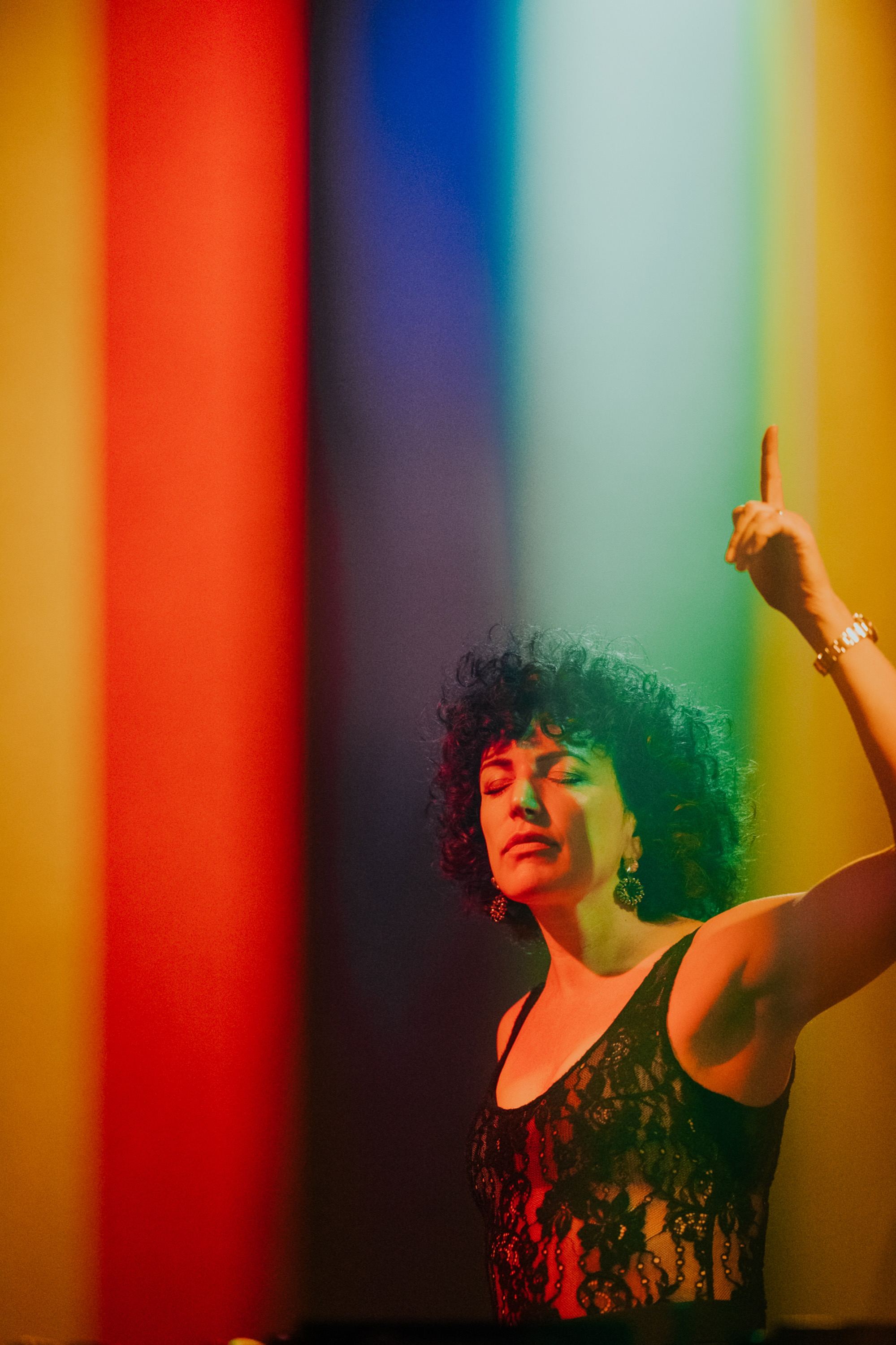 Annie pointing up in rainbow light