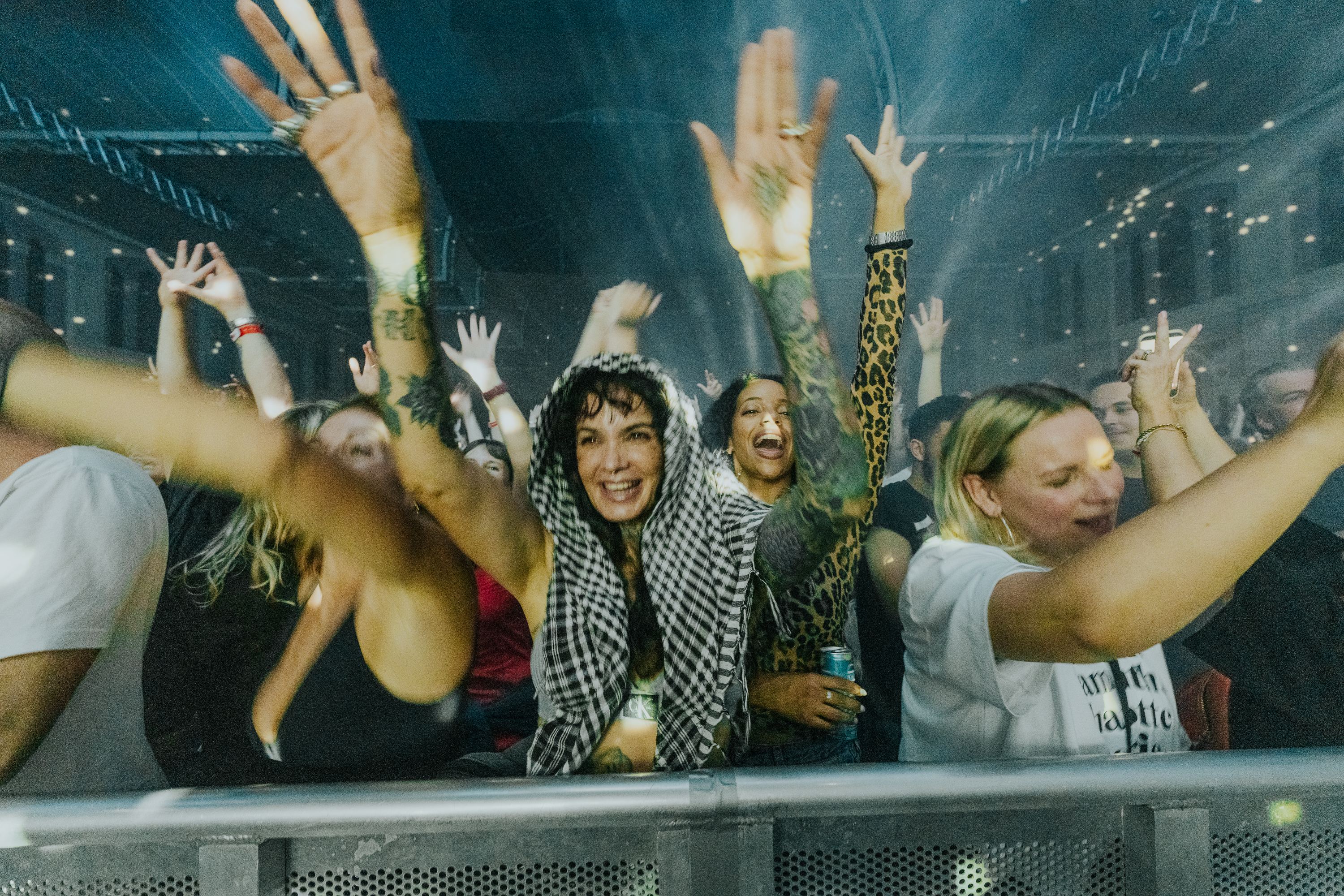 Friends at the barrier with their hands in the air